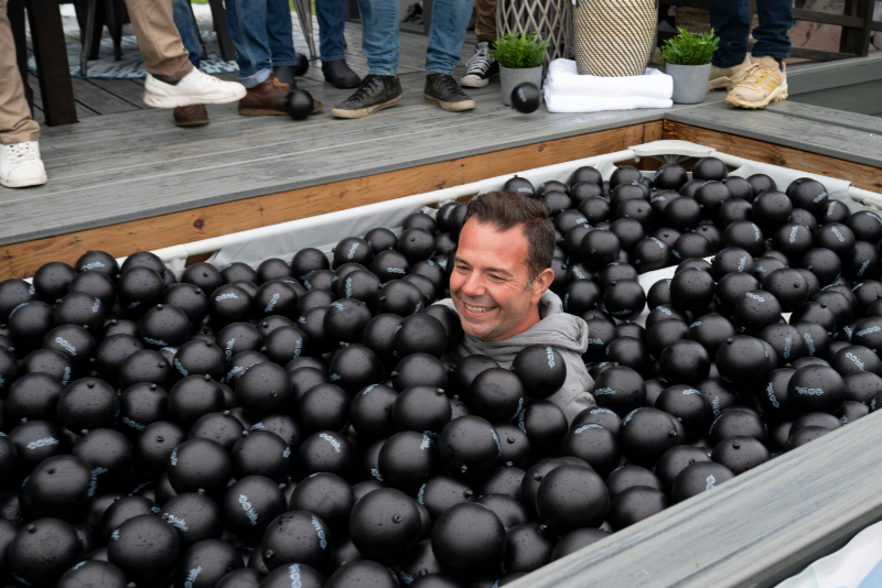 Divine Flooring CEO Carlos Soares jumps in playhouse lottery pool designed and built by Calbridge Homes for the 2022 Barley & Smoke charity fundraising event