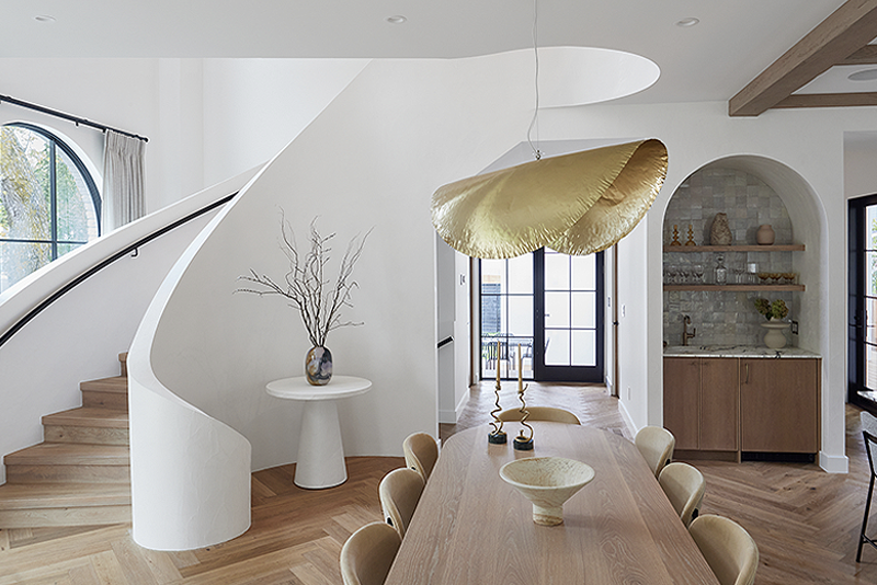 Stunning home interior with a white curved staircase and herringbone hardwood flooring