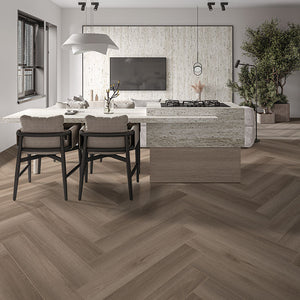 Dark oak herringbone floor in a dining and living space with a light colored stone dining table. and earth tone furniture