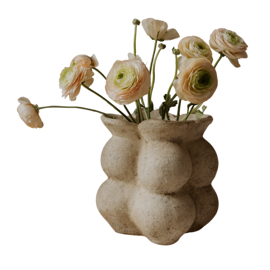 Decorative vase with a unique design holding flowers on a white background