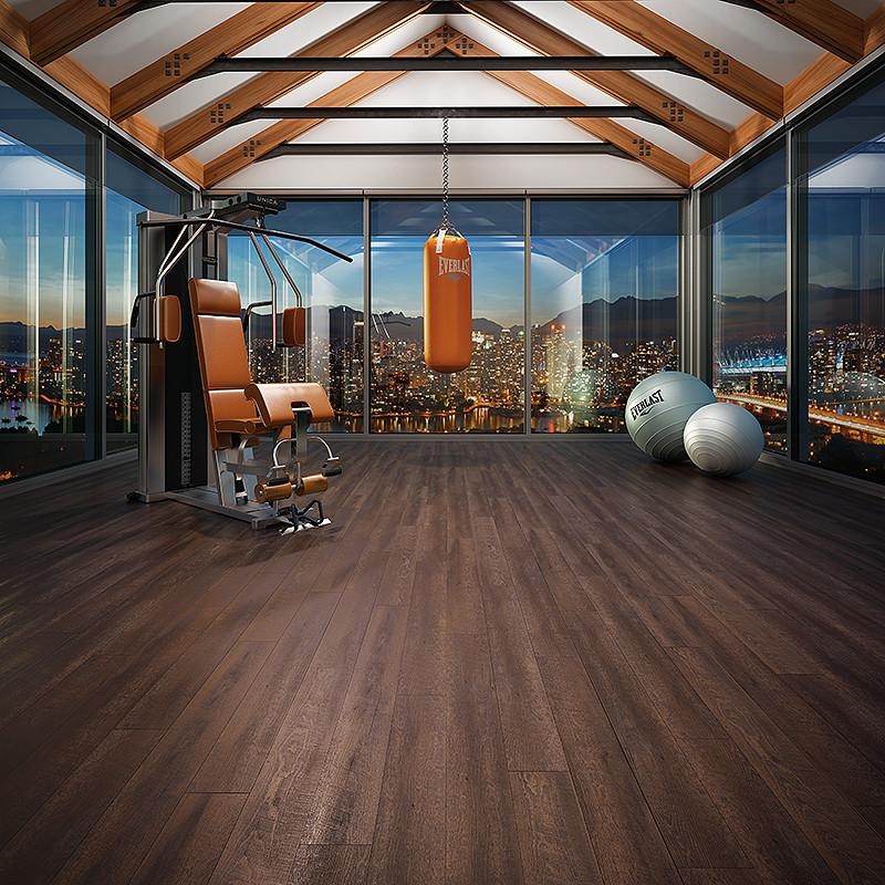 Close-up of textured wood flooring in a medium brown tone with visible grain patterns and subtle grey undertones.